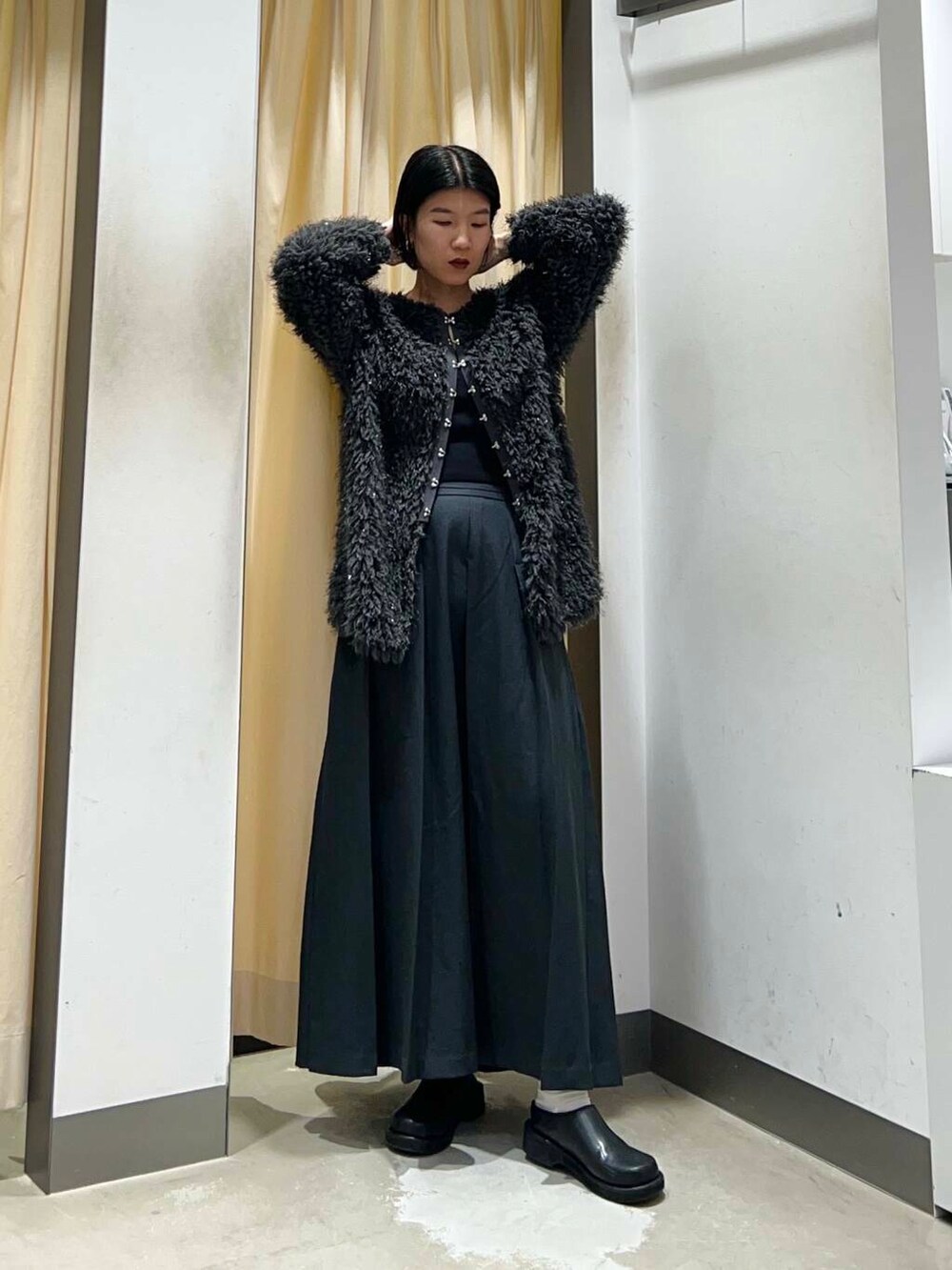 グレー系のワンピース、ブラック系のショルダーバッグ、グレー系のニット/セーターを着用したレディースの冬コーディネートの5枚目の写真