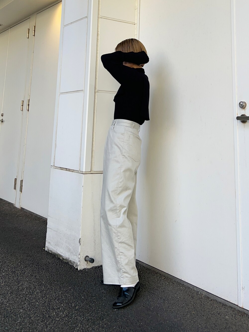 ブラック系のその他シューズ、ブラック系のニット/セーター、グレー系のその他パンツを着用したレディースの秋コーディネートの2枚目の写真