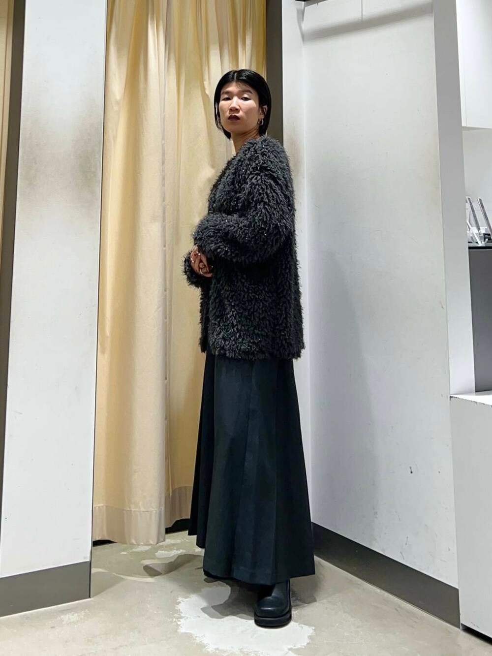 グレー系のワンピース、ブラック系のショルダーバッグ、グレー系のニット/セーターを着用したレディースの冬コーディネートの3枚目の写真