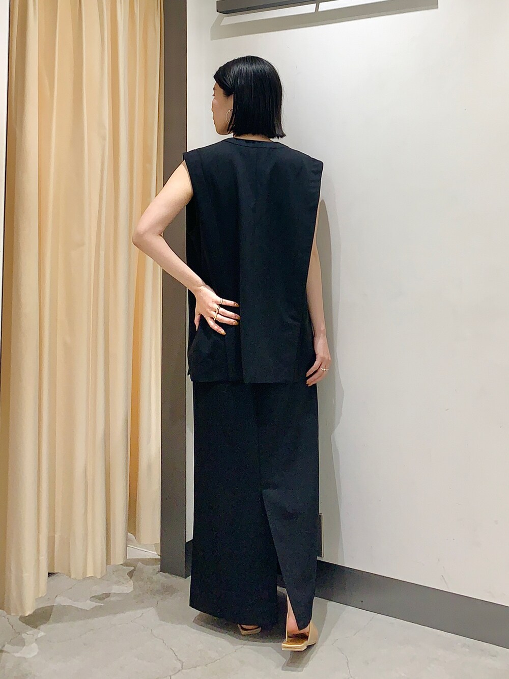 ブラック系のワンピース、グリーン系のTシャツ/カットソー、ベージュ系のサンダルを着用したレディースの夏コーディネートの4枚目の写真