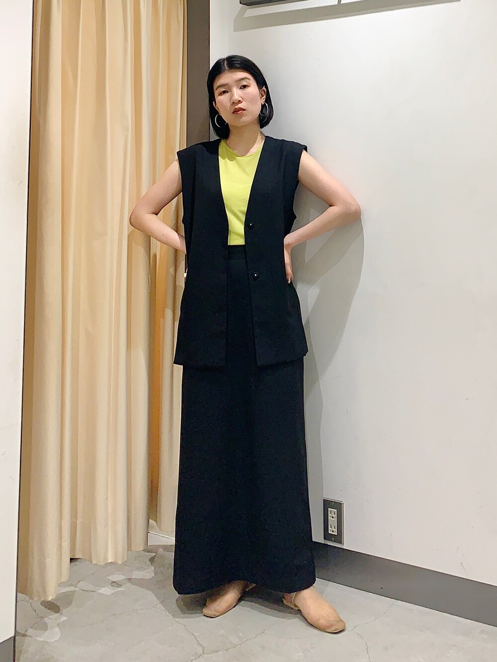 ブラック系のワンピース、グリーン系のTシャツ/カットソー、ベージュ系のサンダルを着用したレディースの夏コーディネートの3枚目の写真