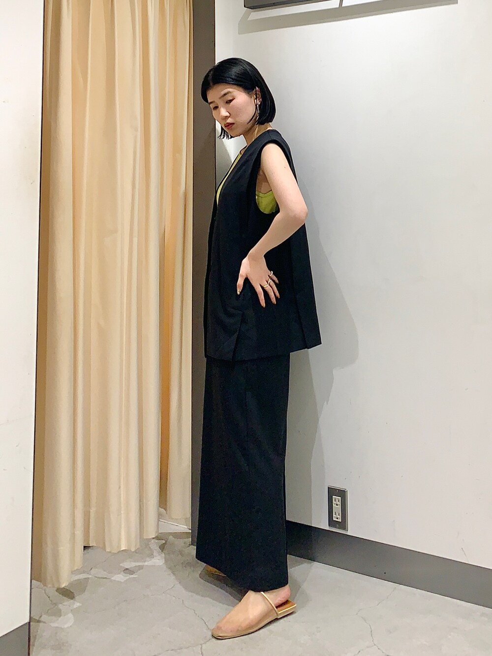 ブラック系のワンピース、グリーン系のTシャツ/カットソー、ベージュ系のサンダルを着用したレディースの夏コーディネートの2枚目の写真