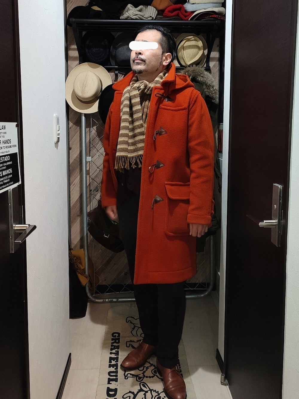 ブラウン系のスラックス、ブラウン系のドレスシューズ、オレンジ系のダッフルコートを着用したメンズの冬コーディネートの2枚目の写真