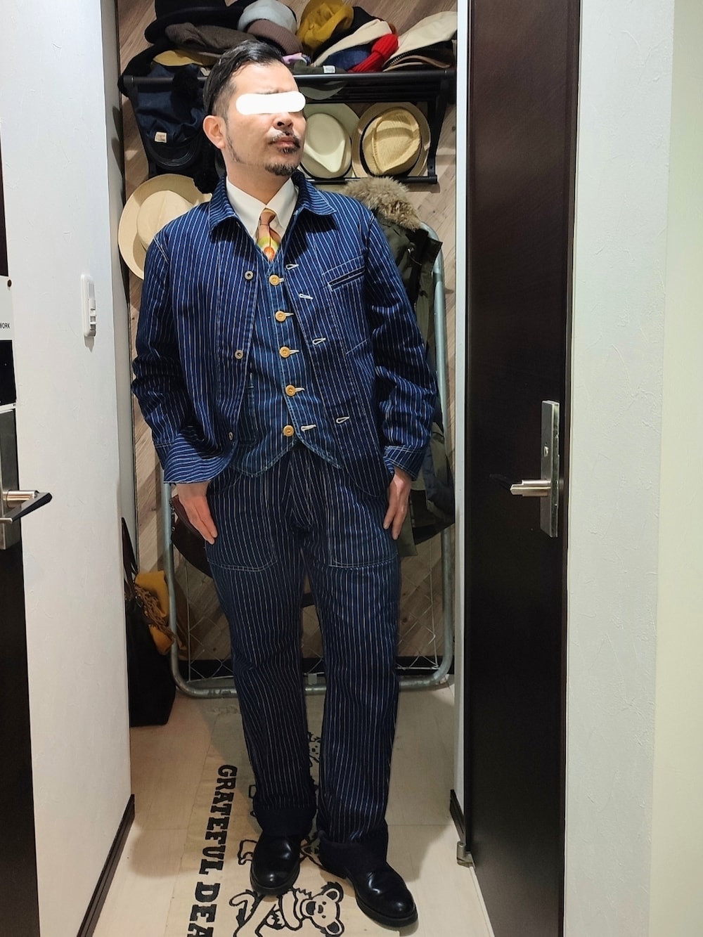 ブルー系のデニムパンツ、ブラック系のドレスシューズ、ブルー系のカバーオールを着用したメンズの冬コーディネートの2枚目の写真