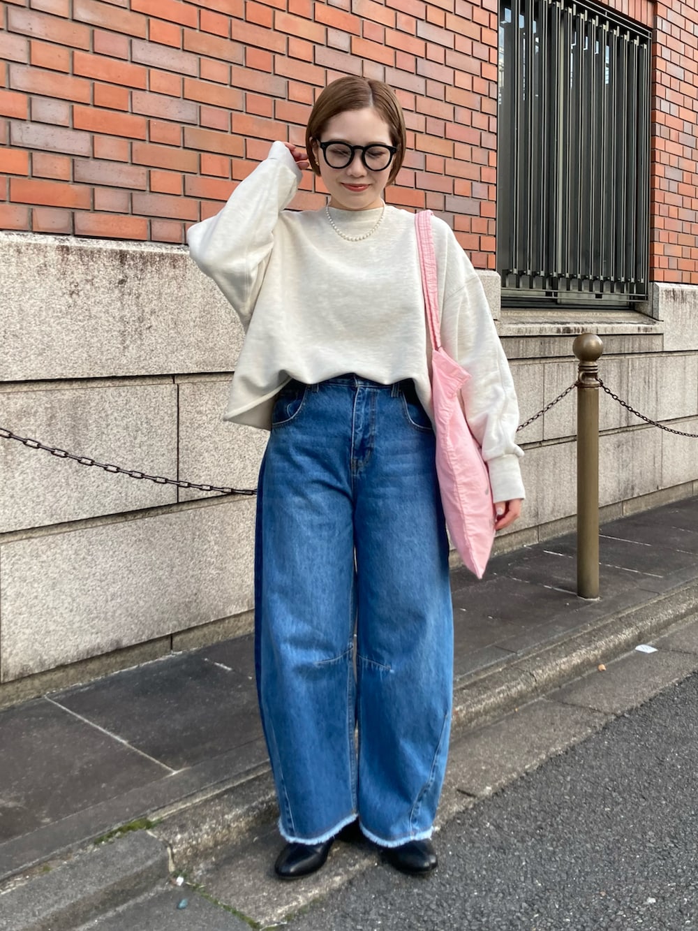 ブラック系のブーツ、ブルー系のデニムパンツ、ピンク系のバッグを着用したレディースの冬コーディネートの2枚目の写真