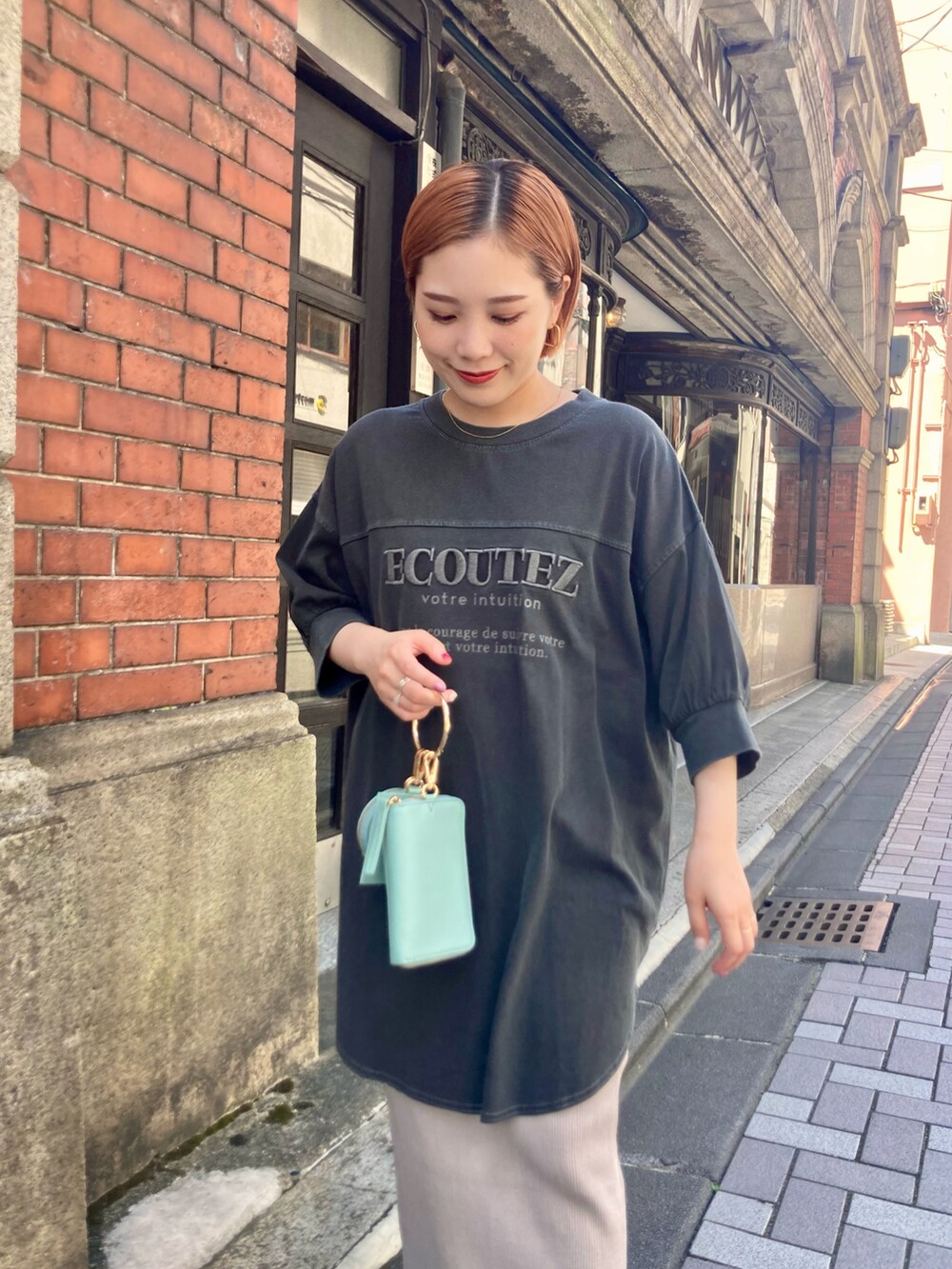 ベージュ系のスカート、ブルー系のショルダーバッグ、グレー系のTシャツ/カットソーを着用したレディースの夏コーディネートの5枚目の写真