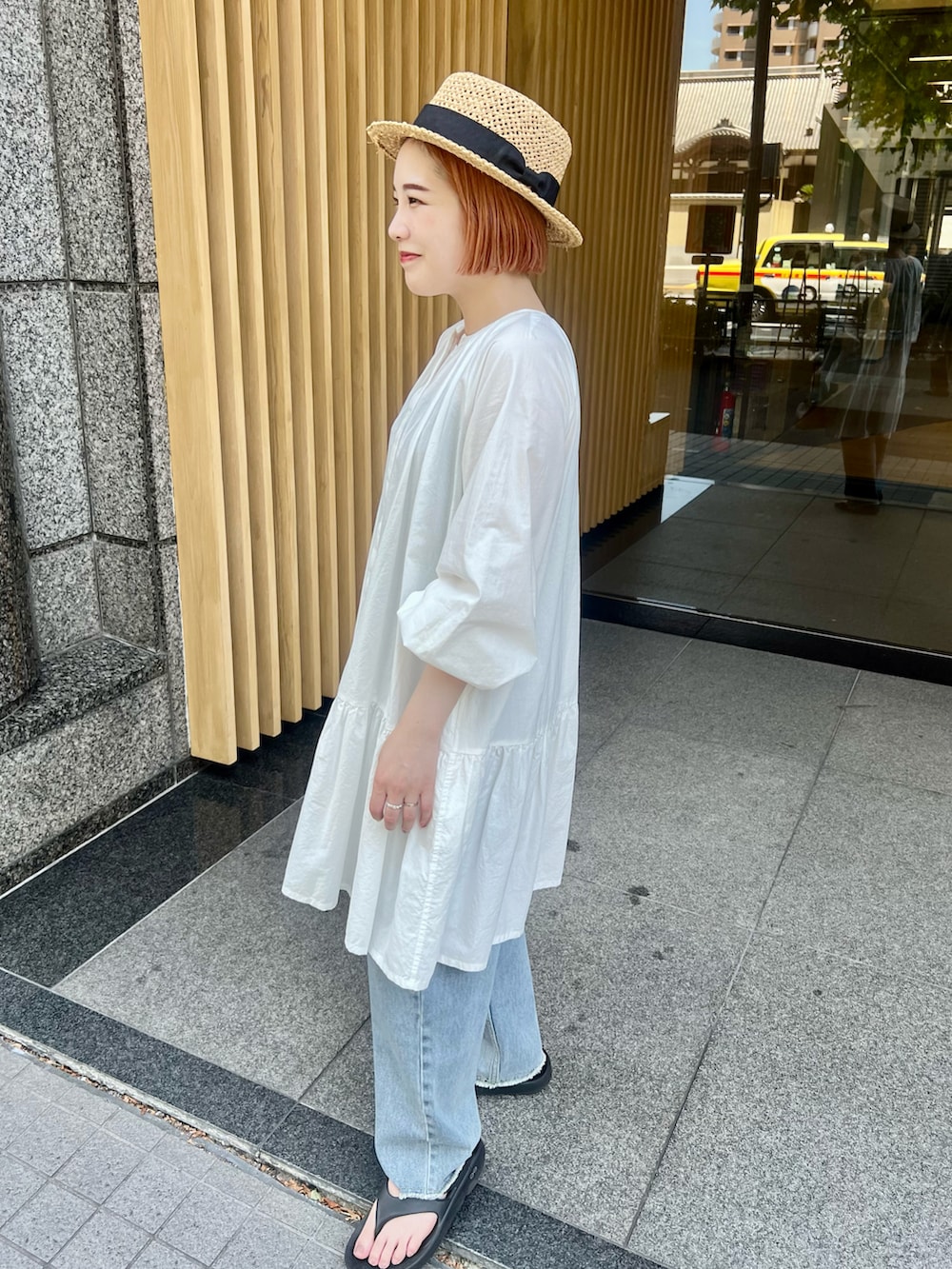 ブラック系のサンダル、ホワイト系のシャツ/ブラウス、ブルー系のデニムパンツを着用したレディースの夏コーディネートの3枚目の写真