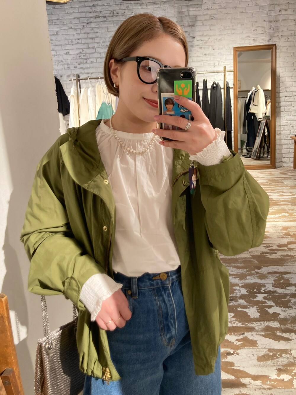 ブラック系のブーツ、ブルー系のデニムパンツ、ゴールド系のショルダーバッグを着用したレディースの冬コーディネートの4枚目の写真