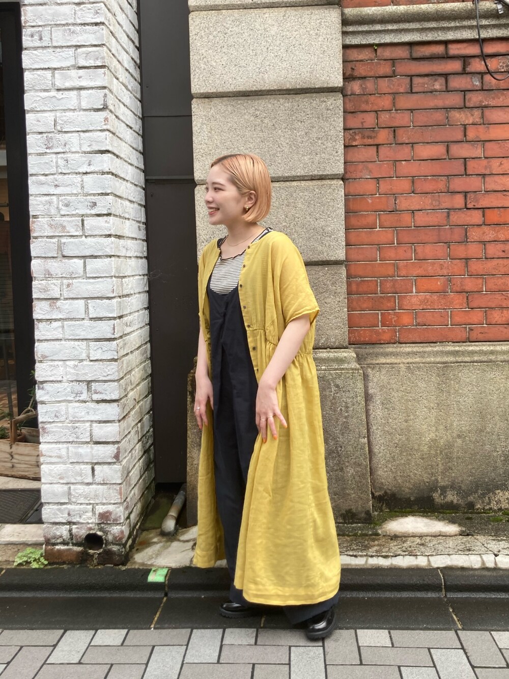 ブルー系のサロペット/オーバーオール、ブラック系のローファー、イエロー系のワンピースを着用したレディースの夏コーディネートの4枚目の写真