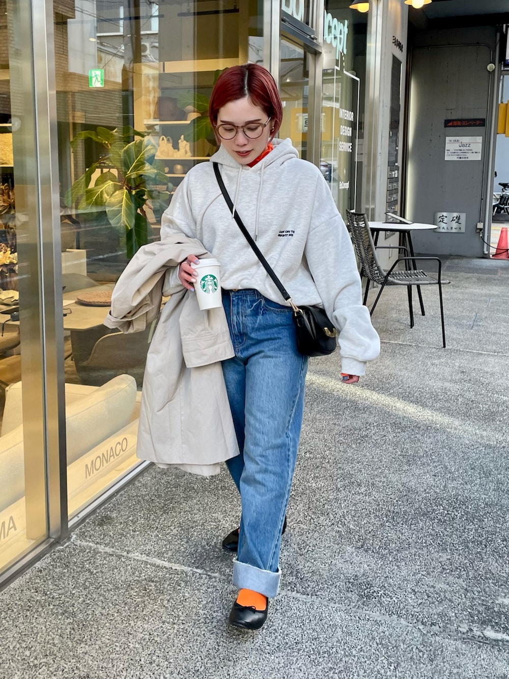 グレー系のパーカー、ブルー系のデニムパンツ、ブラック系のショルダーバッグを着用したレディースの冬コーディネートの2枚目の写真