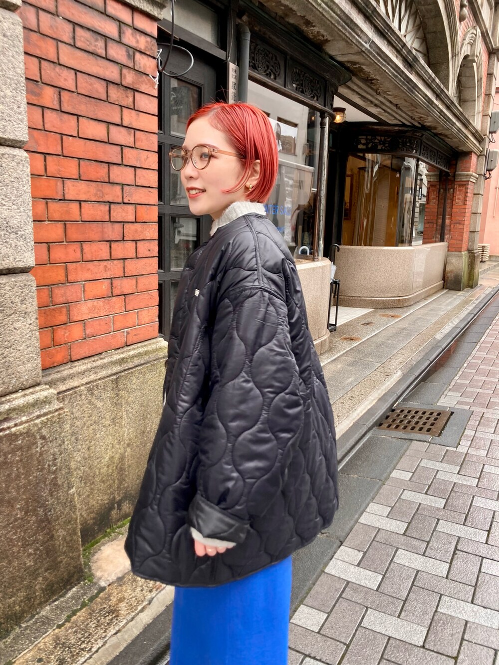 ブルー系のスカート、ブラック系のその他アウター、ベージュ系のニット/セーターを着用したレディースの冬コーディネートの5枚目の写真