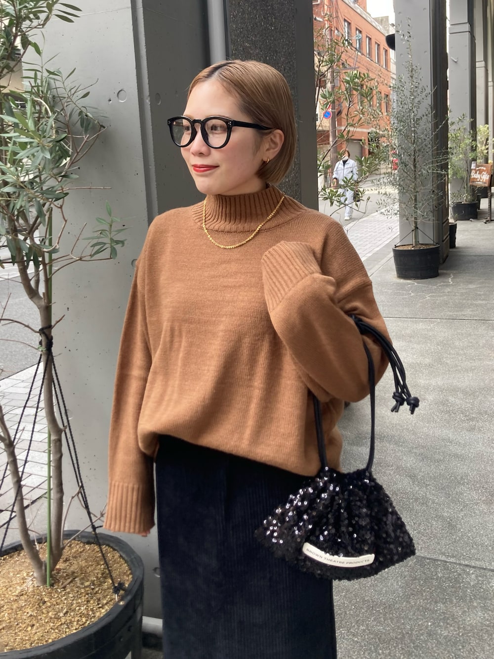 ブラック系のスカート、ベージュ系のニット/セーター、ブラック系のショルダーバッグを着用したレディースの冬コーディネートの5枚目の写真