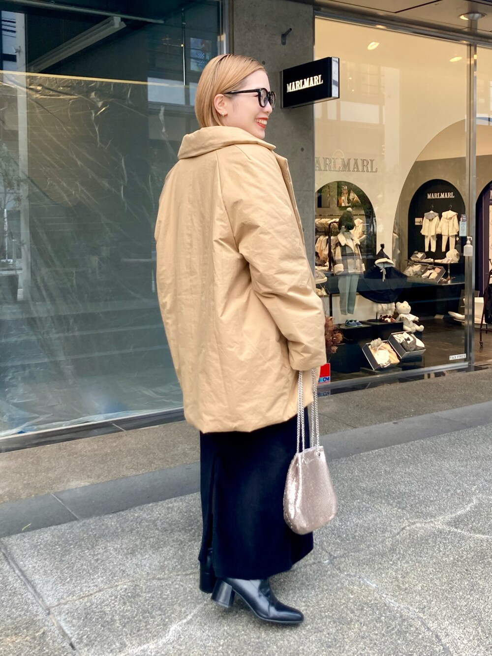 ベージュ系のダウンジャケット/コート、ベージュ系のスウェット、ゴールド系のショルダーバッグを着用したレディースの秋コーディネートの3枚目の写真