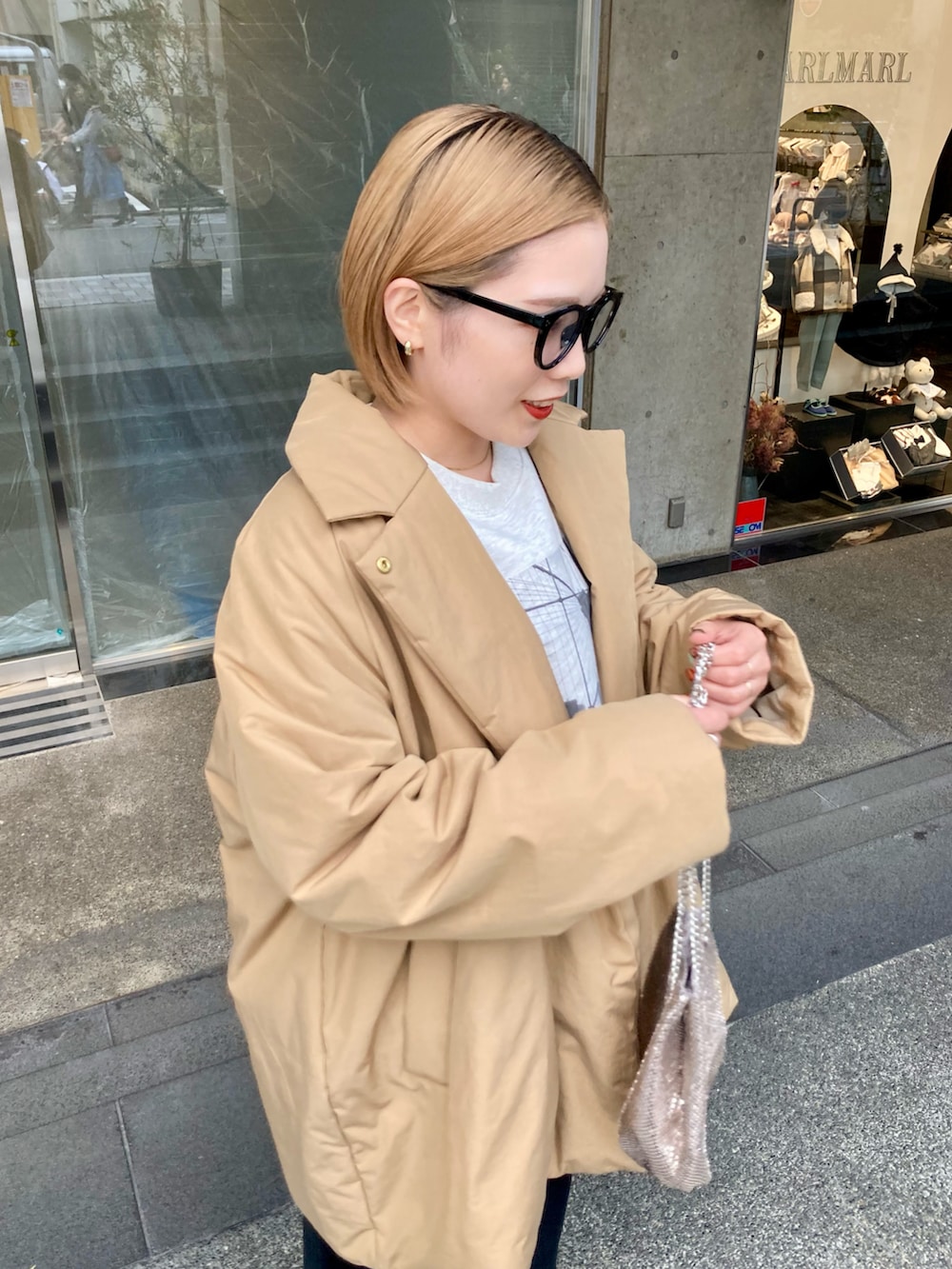 ベージュ系のダウンジャケット/コート、ベージュ系のスウェット、ゴールド系のショルダーバッグを着用したレディースの秋コーディネートの4枚目の写真