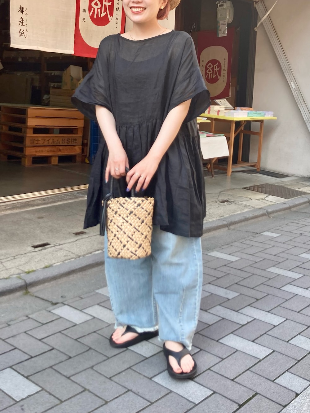 ブラック系のシャツ/ブラウス、ブルー系のデニムパンツ、ブラック系のサンダルを着用したレディースの夏コーディネートの2枚目の写真