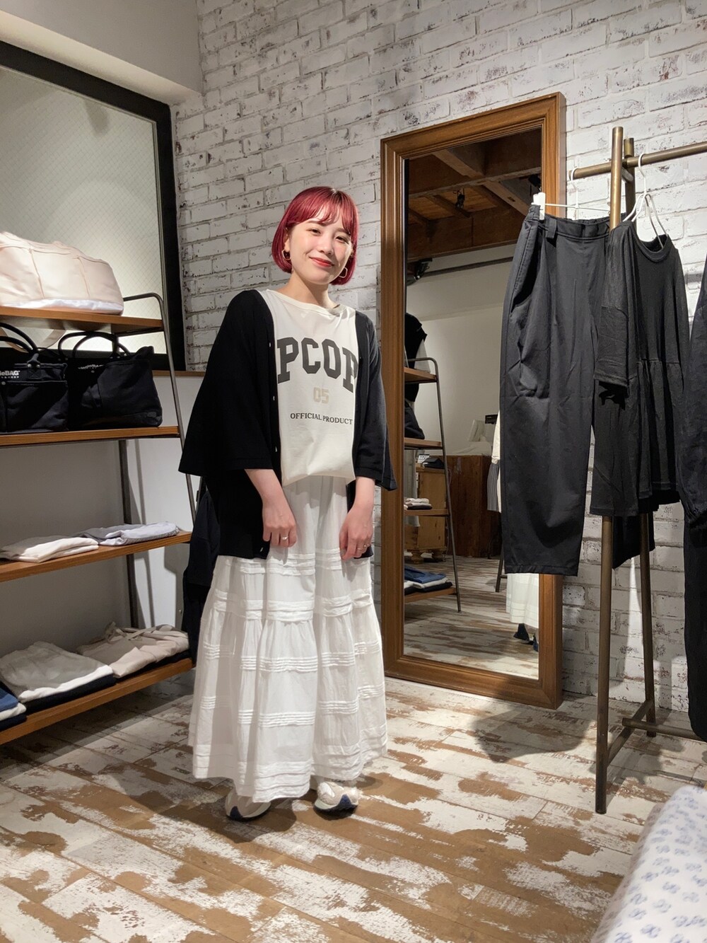 ブラック系のカーディガン/ボレロ、ホワイト系のTシャツ/カットソー、ホワイト系のスカートを着用したレディースの春コーディネートの3枚目の写真