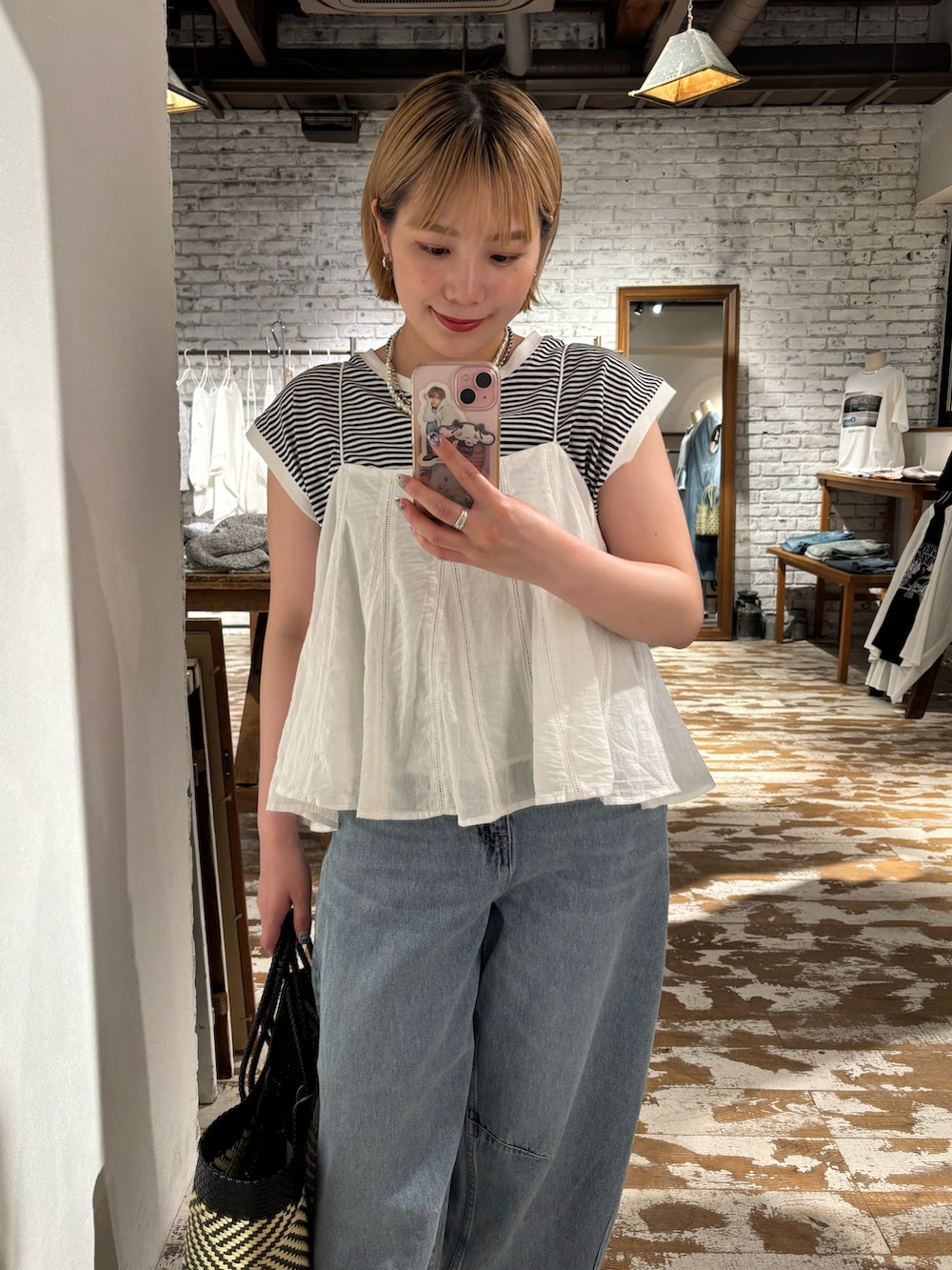 ホワイト系のキャミソール、ブラック系のTシャツ/カットソー、ブルー系のデニムパンツを着用したレディースの夏コーディネートの3枚目の写真