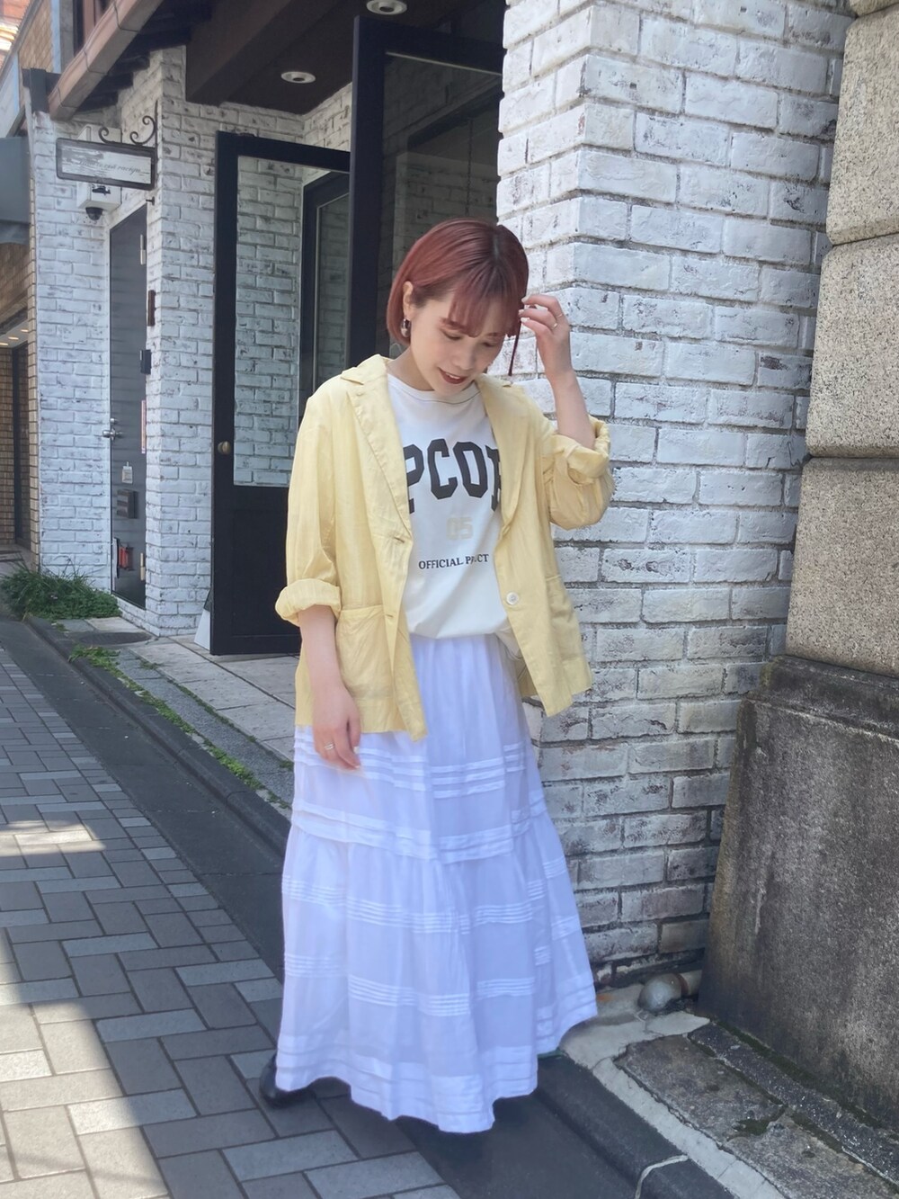 イエロー系のテーラードジャケット、ホワイト系のTシャツ/カットソー、ホワイト系のスカートを着用したレディースの夏コーディネートの4枚目の写真