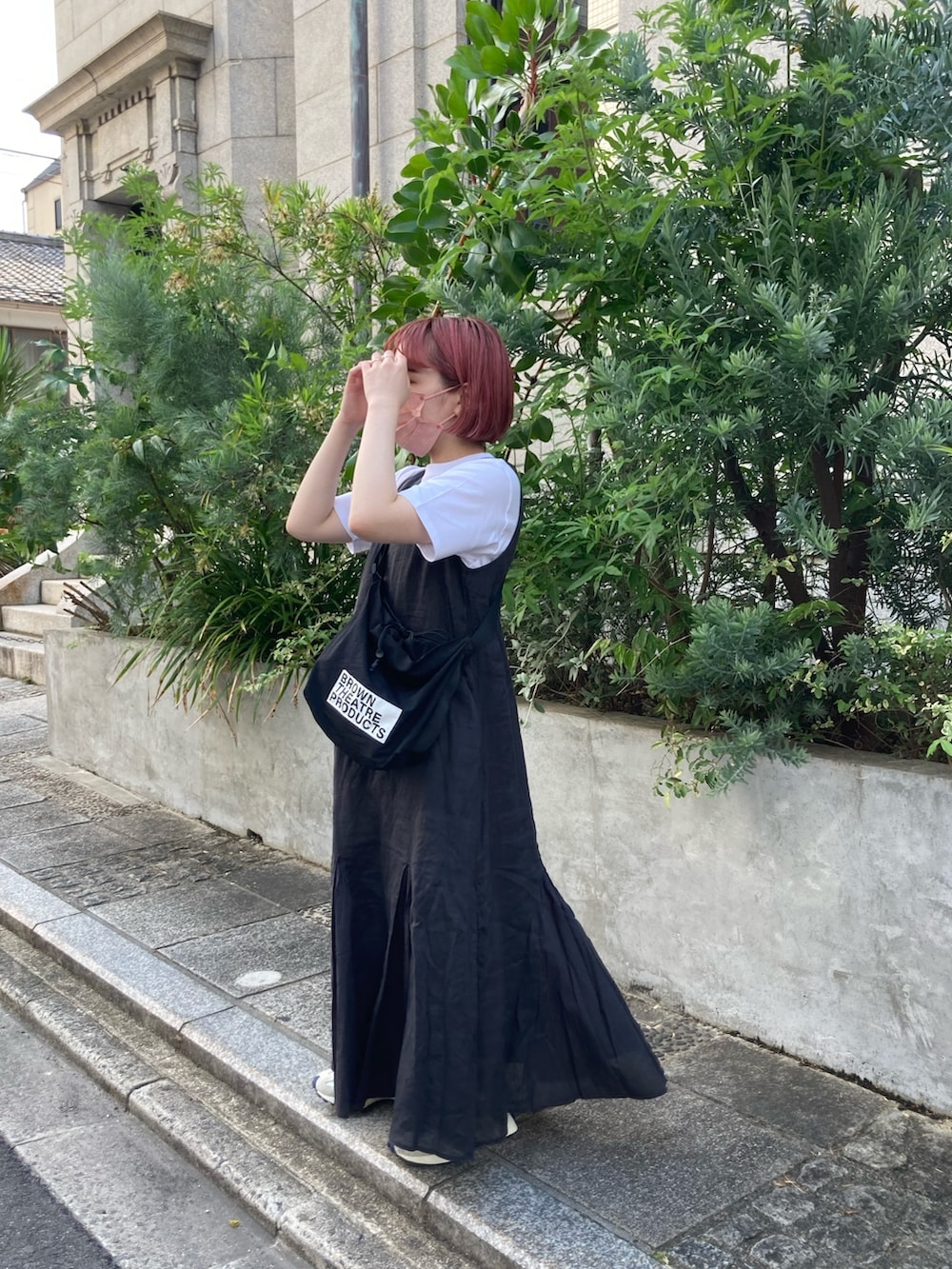 グレー系のワンピース、ホワイト系のTシャツ/カットソー、ベージュ系のスニーカーを着用したレディースの夏コーディネートの2枚目の写真