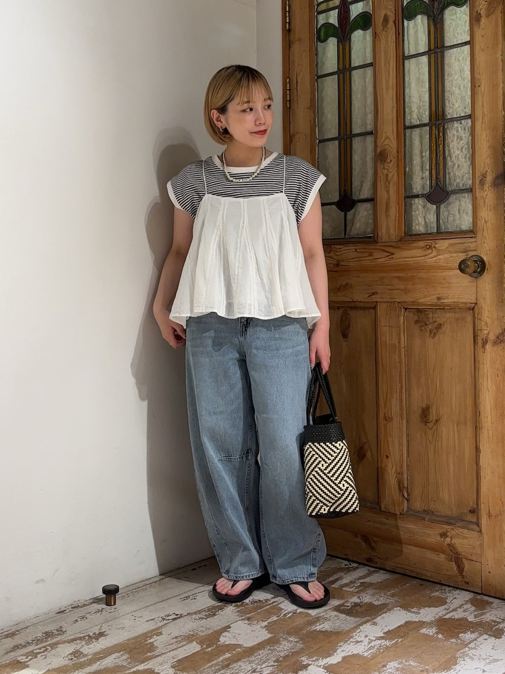 ホワイト系のキャミソール、ブラック系のTシャツ/カットソー、ブルー系のデニムパンツを着用したレディースの夏コーディネートの2枚目の写真