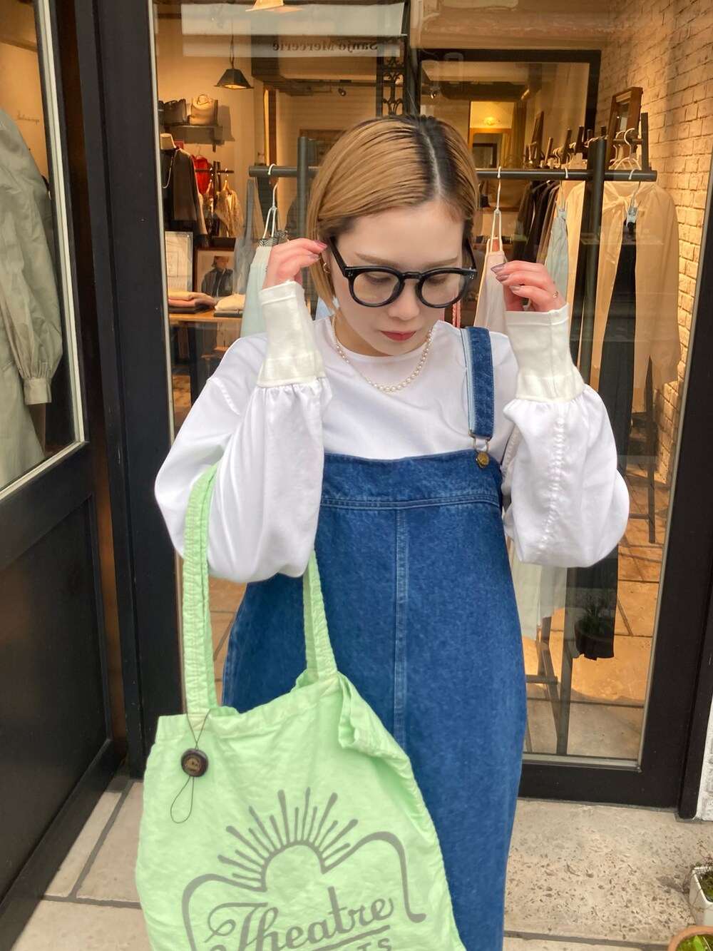 ブルー系のジャンパースカート、グリーン系のバッグ、ホワイト系のシャツ/ブラウスを着用したレディースの冬コーディネートの5枚目の写真