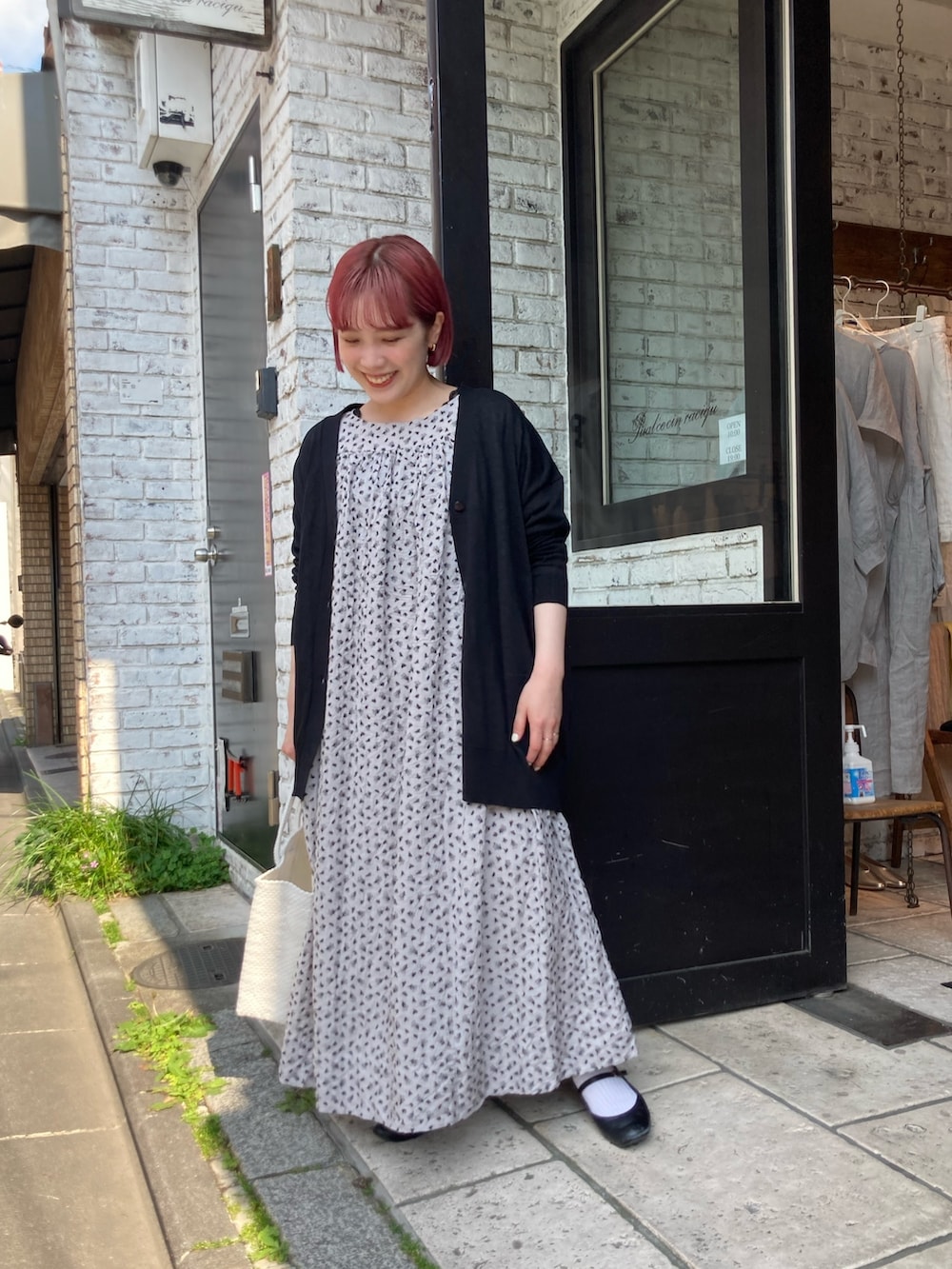 ブラック系のカーディガン/ボレロ、ベージュ系のワンピースを着用したレディースの春コーディネートの2枚目の写真