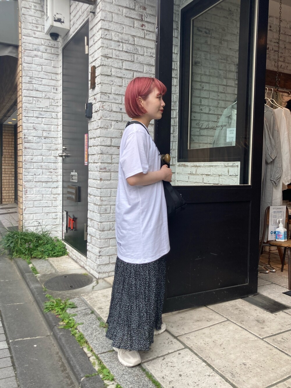 ホワイト系のTシャツ/カットソー、ブラック系のショルダーバッグ、ブラック系のスカートを着用したレディースの春コーディネートの3枚目の写真