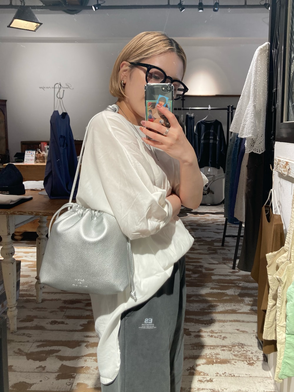 シルバー系のショルダーバッグ、グレー系のスウェットパンツ、ホワイト系のシャツ/ブラウスを着用したレディースの秋コーディネートの4枚目の写真