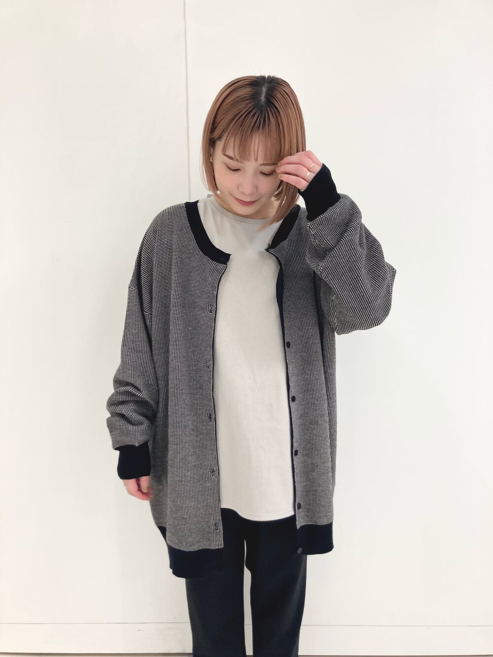 ブラック系のカーディガン/ボレロ、ベージュ系のTシャツ/カットソー、ブラック系のデニムパンツを着用したレディースの秋コーディネートの2枚目の写真