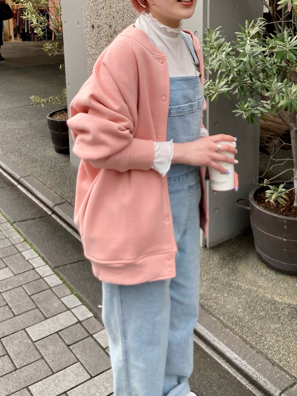 ピンク系のカーディガン/ボレロ、ブルー系のサロペット/オーバーオール、ホワイト系のTシャツ/カットソーを着用したレディースの冬コーディネートの5枚目の写真