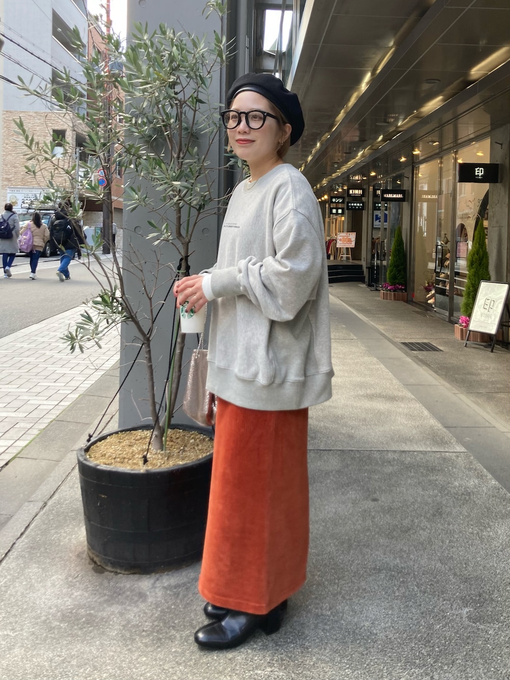 ブラック系のブーツ、オレンジ系のスカート、オレンジ系のスカートを着用したレディースの冬コーディネートの5枚目の写真