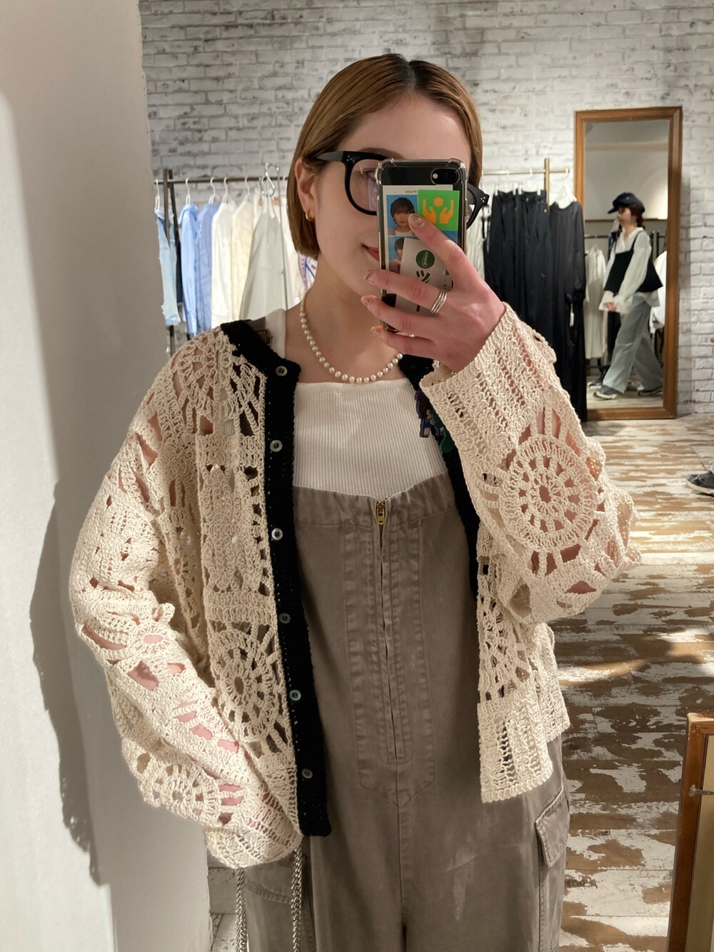 ブラック系のローファー、ゴールド系のショルダーバッグ、ベージュ系のサロペット/オーバーオールを着用したレディースの春コーディネートの4枚目の写真