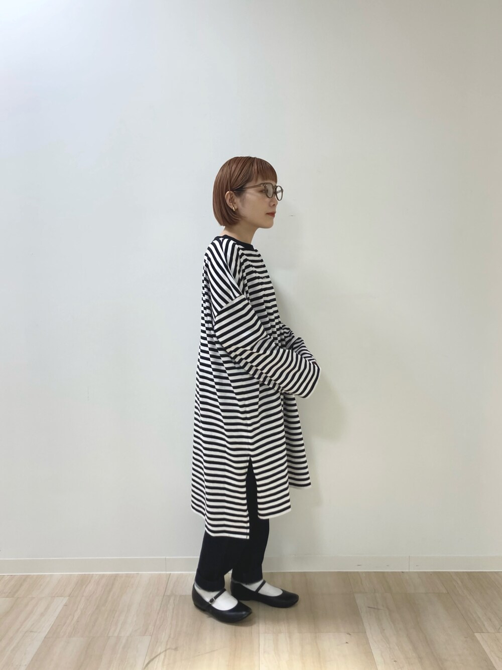 ブラック系のカーディガン/ボレロ、ホワイト系のTシャツ/カットソー、ブルー系のデニムパンツを着用したレディースの春コーディネートの4枚目の写真