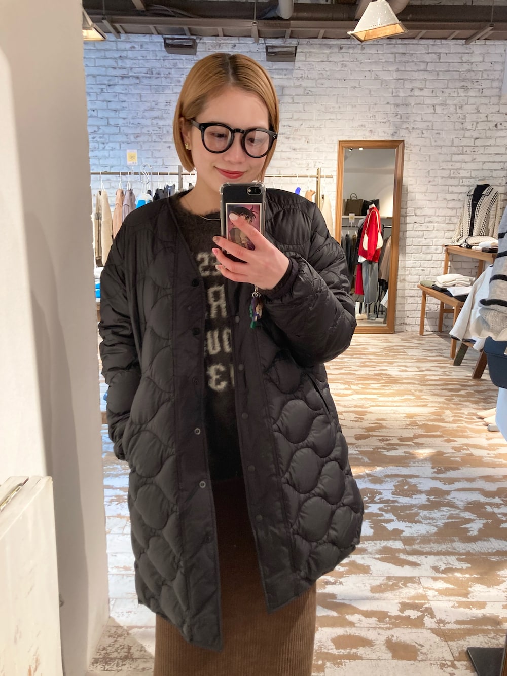 ブラック系のブーツ、ゴールド系のショルダーバッグ、ブラウン系のスカートを着用したレディースの冬コーディネートの4枚目の写真