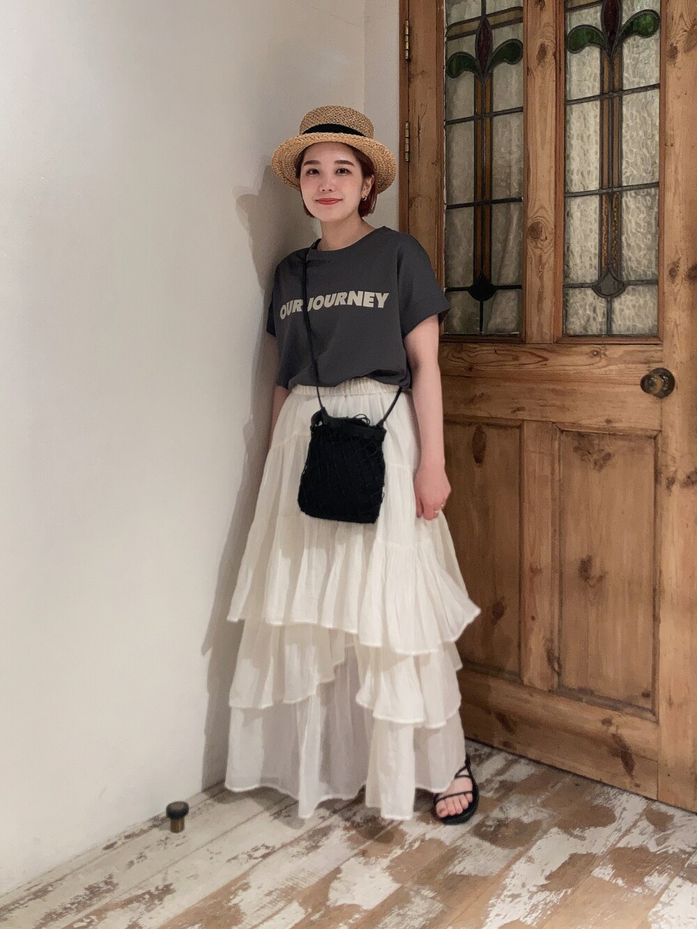 グレー系のTシャツ/カットソー、ホワイト系のスカート、ブラック系のサンダルを着用したレディースの夏コーディネートの4枚目の写真