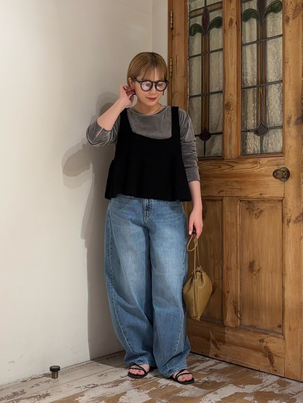 ブラウン系のショルダーバッグ、ブラック系のニット/セーター、グレー系のTシャツ/カットソーを着用したレディースの秋コーディネートの2枚目の写真