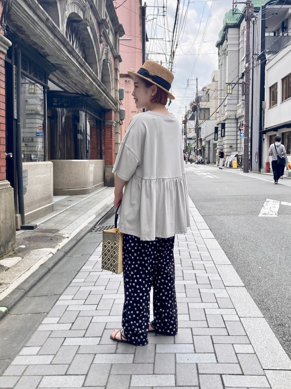 グレー系のTシャツ/カットソー、ブラック系のその他パンツ、ベージュ系のショルダーバッグを着用したレディースの夏コーディネートの4枚目の写真