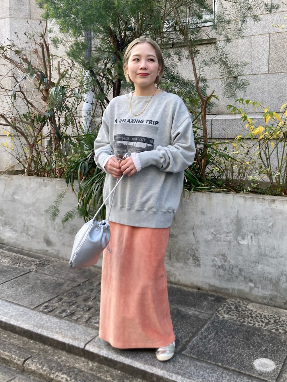 ピンク系のスカート、グレー系のスウェット、ホワイト系のTシャツ/カットソーを着用したレディースの冬コーディネートの2枚目の写真