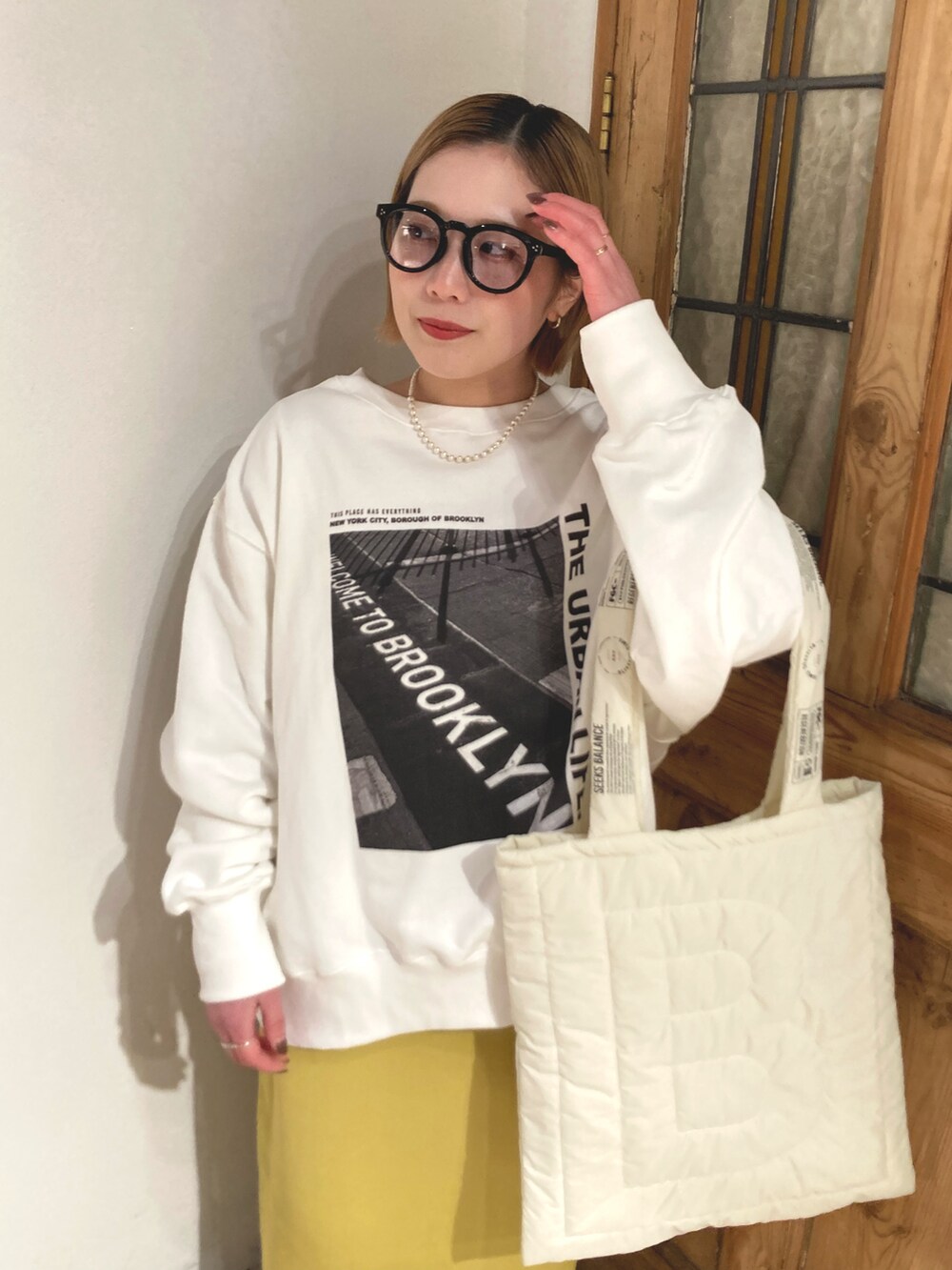 ブラック系のブーツ、イエロー系のスカート、ホワイト系のスウェットを着用したレディースの冬コーディネートの4枚目の写真