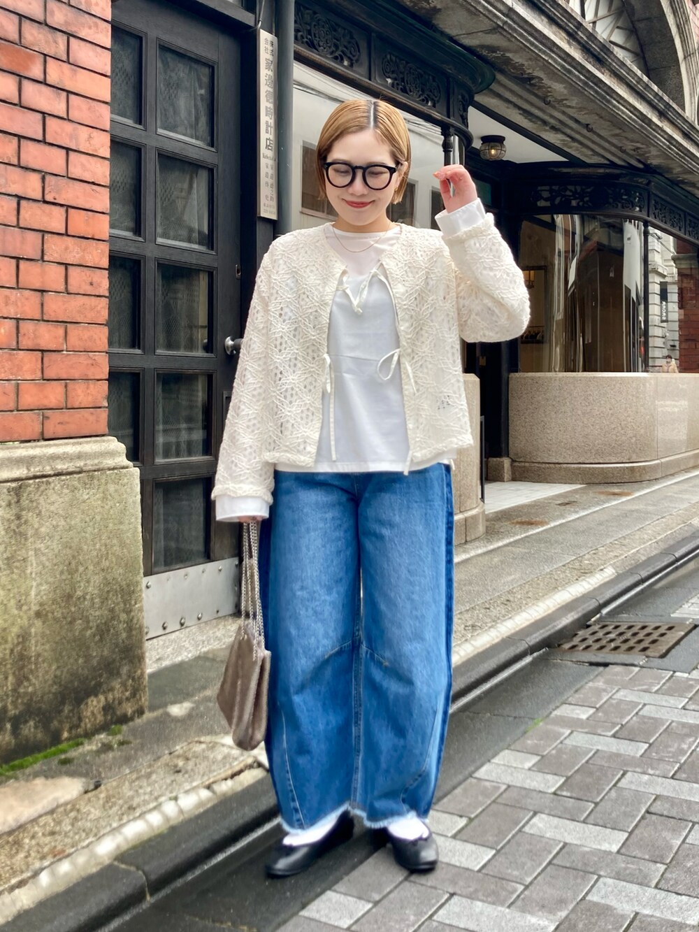 ブルー系のデニムパンツ、ゴールド系のショルダーバッグ、ホワイト系のシャツ/ブラウスを着用したレディースの春コーディネートの3枚目の写真