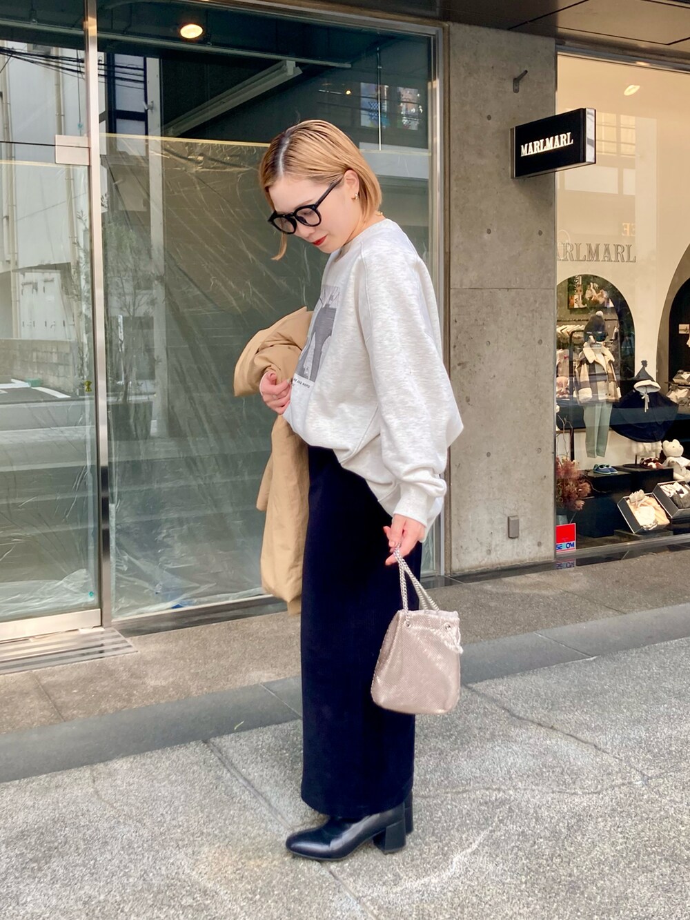 ベージュ系のダウンジャケット/コート、ベージュ系のスウェット、ゴールド系のショルダーバッグを着用したレディースの秋コーディネートの5枚目の写真