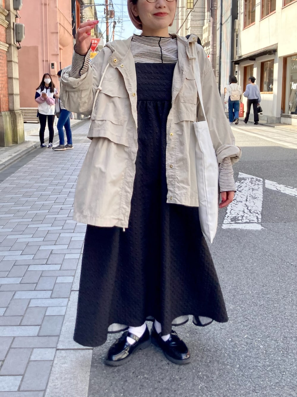 ブラック系のワンピース/ドレス、ブラック系のTシャツ/カットソー、ベージュ系のマウンテンパーカーを着用したレディースの春コーディネートの2枚目の写真