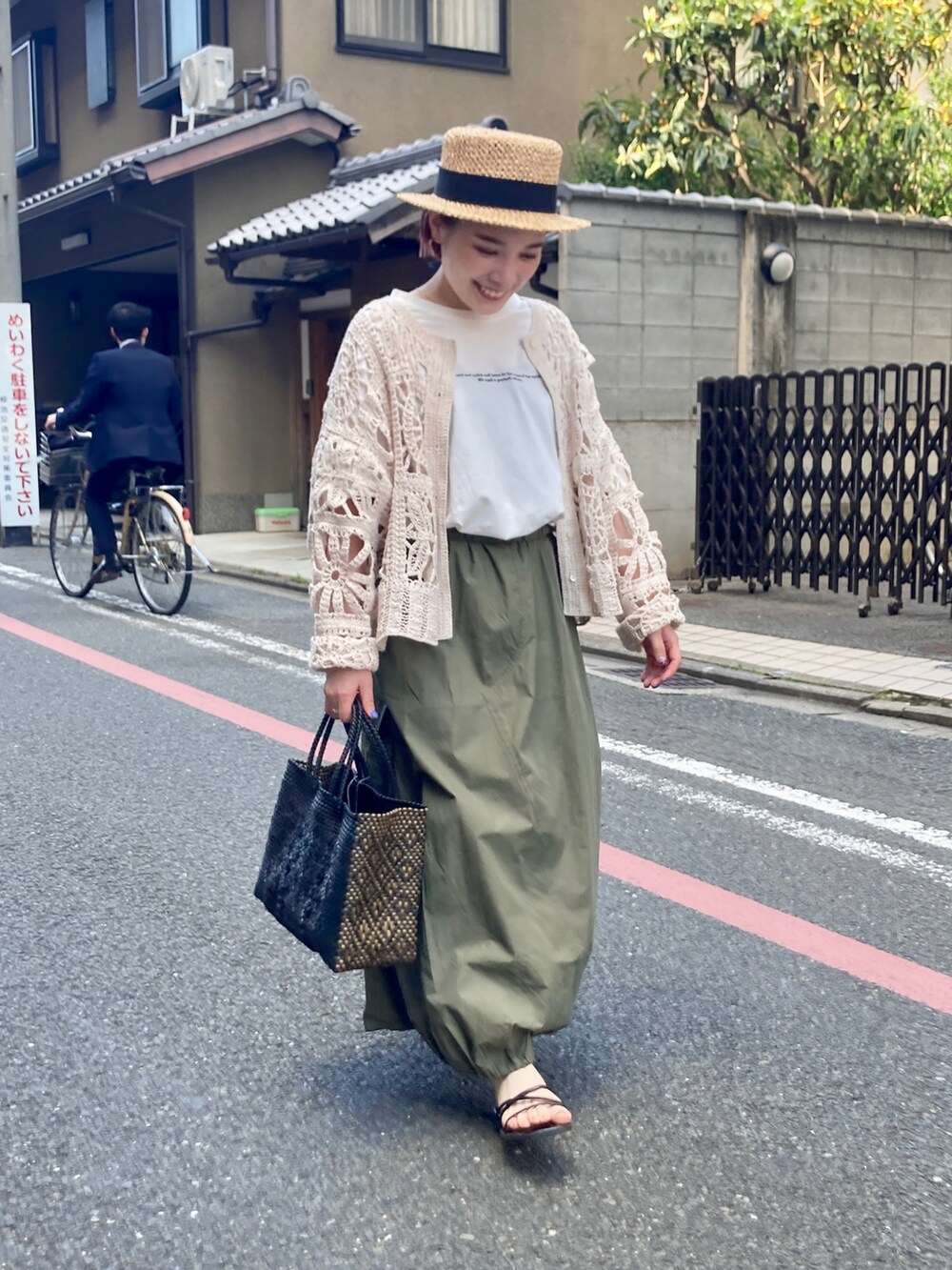 ベージュ系のカーディガン/ボレロ、ホワイト系のTシャツ/カットソー、グリーン系のスカートを着用したレディースの夏コーディネートの3枚目の写真