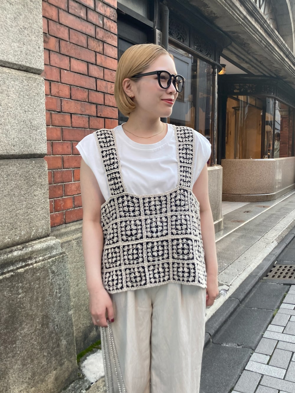 ゴールド系のショルダーバッグ、ブラック系のサンダル、その他のベストを着用したレディースの夏コーディネートの3枚目の写真