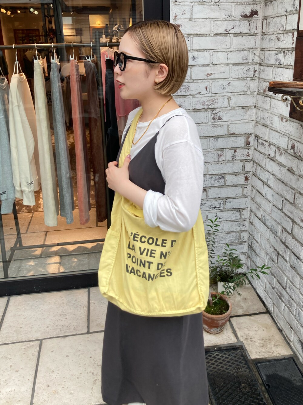 ベージュ系のスニーカー、イエロー系のトートバッグ、グレー系のワンピースを着用したレディースの秋コーディネートの4枚目の写真