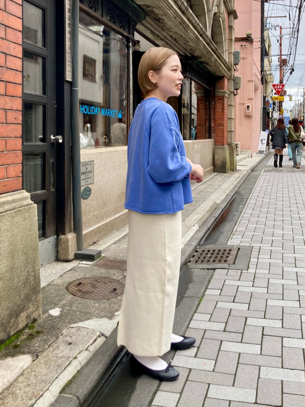 ホワイト系のスカート、ブルー系のスウェット、ブラック系のマウンテンパーカーを着用したレディースの冬コーディネートの4枚目の写真