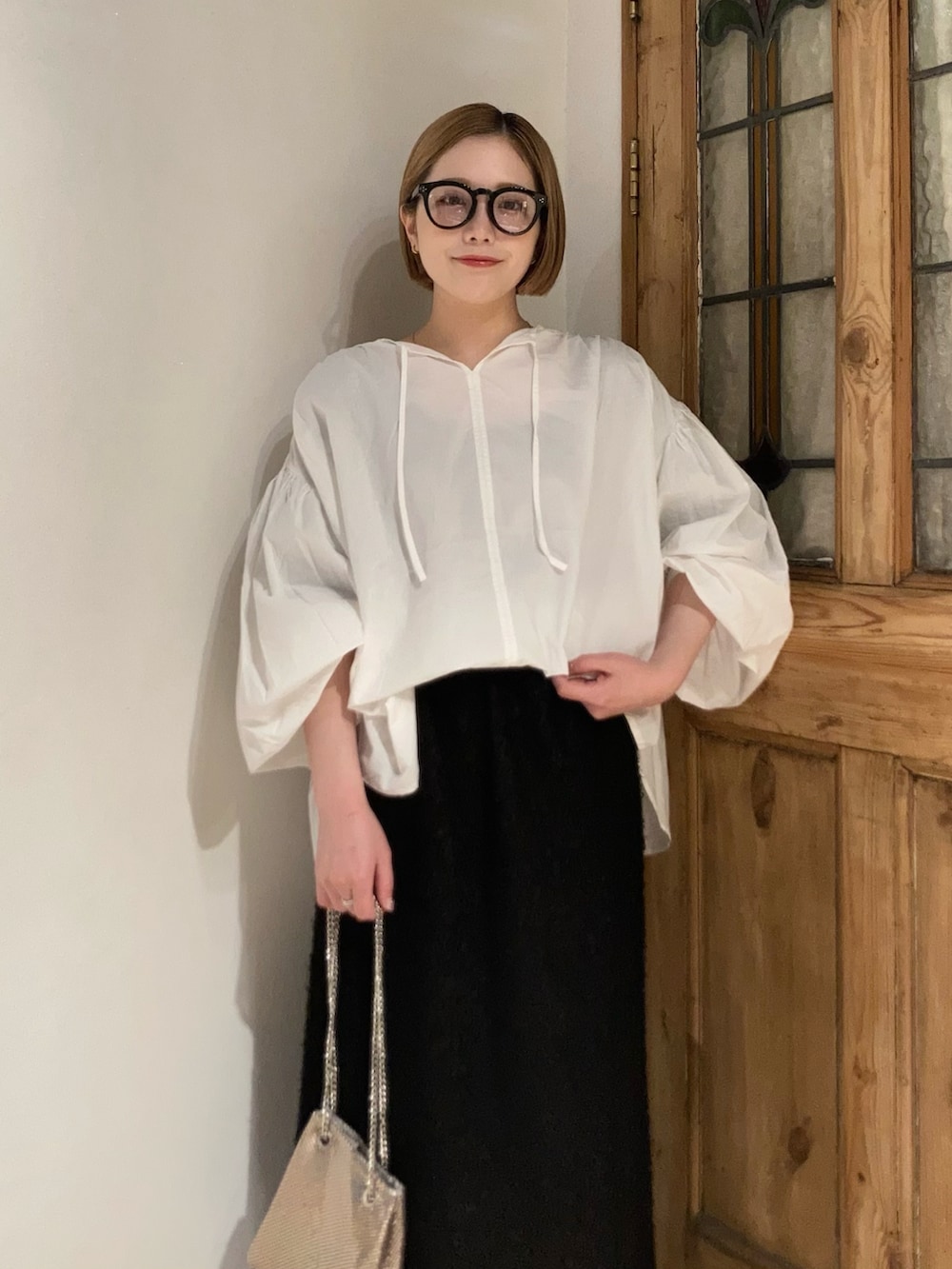 ブラック系のブーツ、ブラック系のスカート、ホワイト系のシャツ/ブラウスを着用したレディースの春コーディネートの5枚目の写真