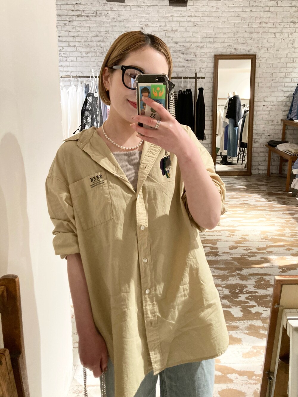 ゴールド系のショルダーバッグ、ブルー系のデニムパンツ、イエロー系のシャツ/ブラウスを着用したレディースの春コーディネートの5枚目の写真