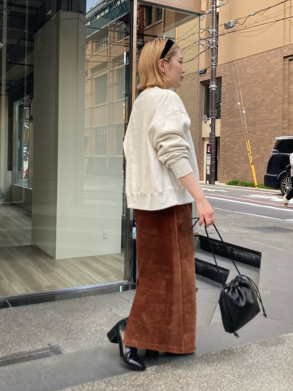 ブラウン系のスカート、ブラウン系のスカート、ブラック系のショルダーバッグを着用したレディースの秋コーディネートの3枚目の写真