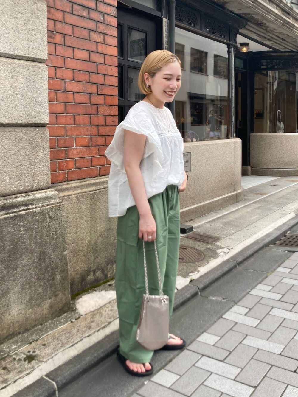 グリーン系のその他パンツ、ホワイト系のシャツ/ブラウス、ブラック系のサンダルを着用したレディースの夏コーディネートの4枚目の写真